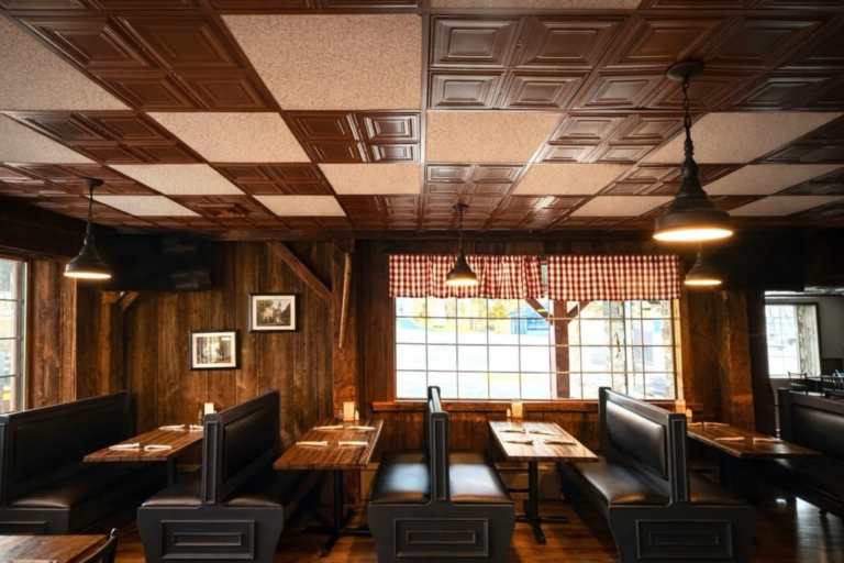 restaurant booth dining area with dark wood paneling and large windows.
